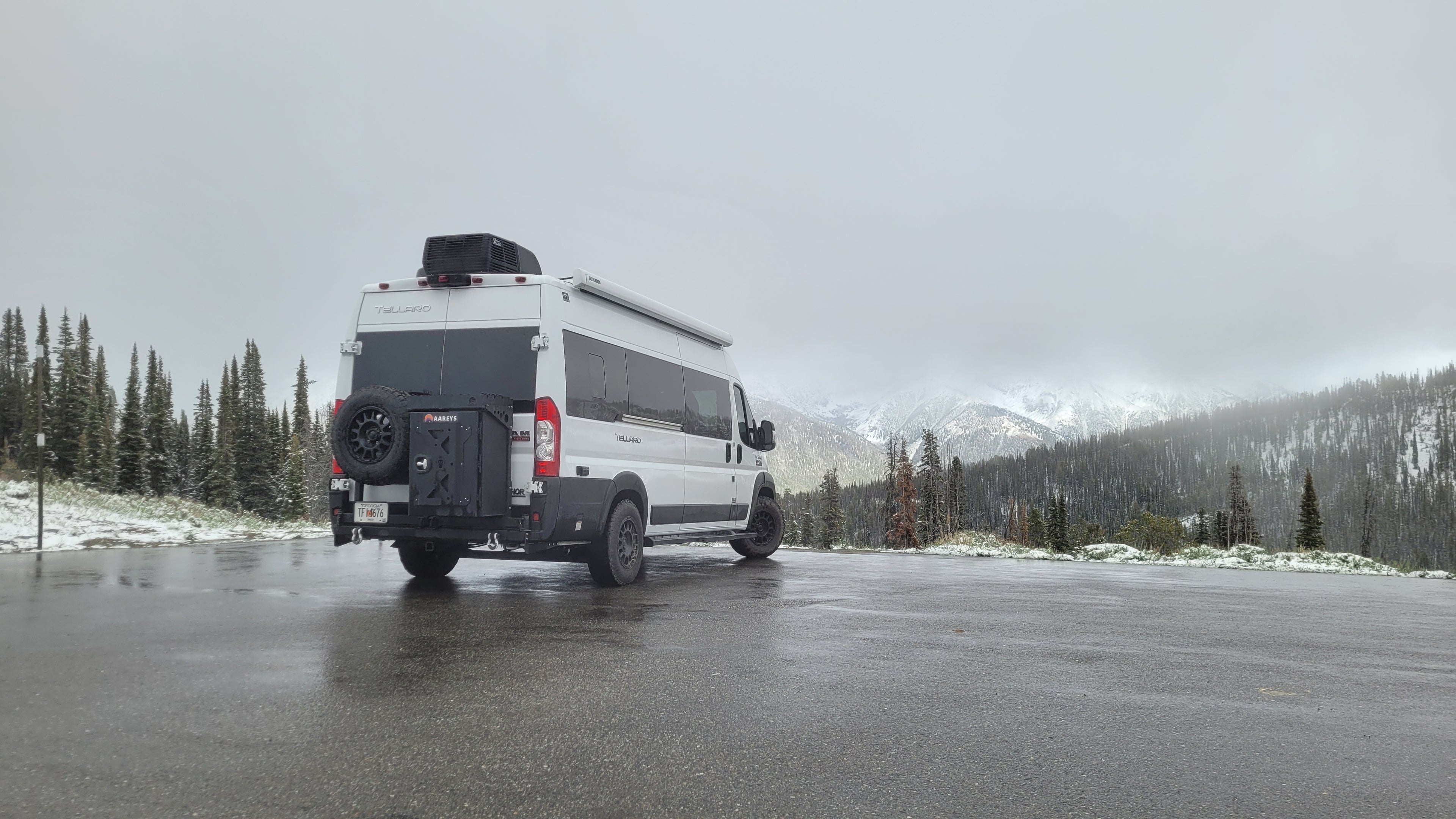 Van equipped with aareys swing arm bumper infront of snowy mountains